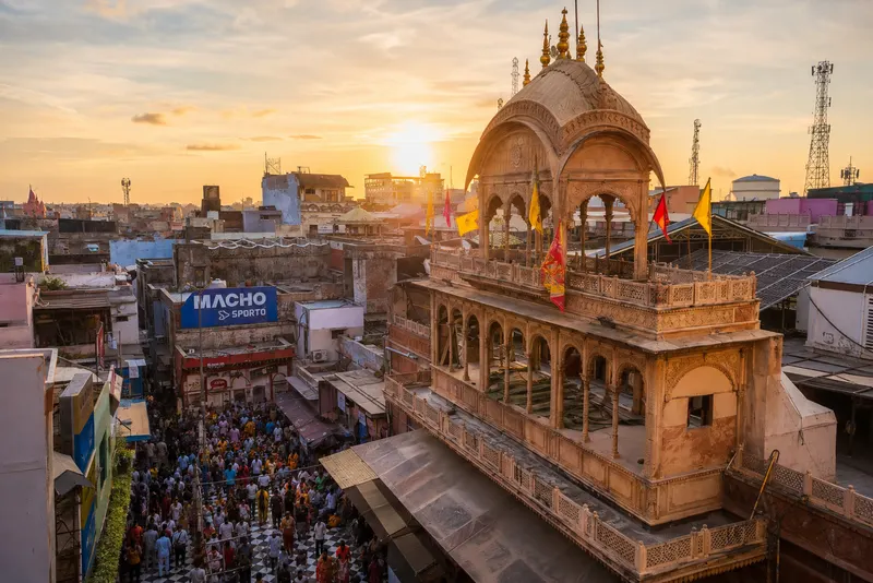 Banke Bihari Temple in Vrindavan at sunset, viewed above the surrounding streets and gathered pilgrims.